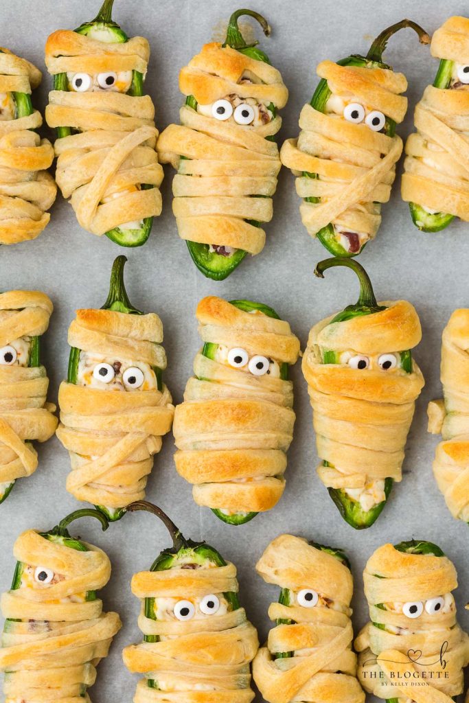 Halloween Jalapeño Popper Mummies are adorably spooky jalapeños, filled with a cream cheese mixture, wrapped in crescent dough, and baked!