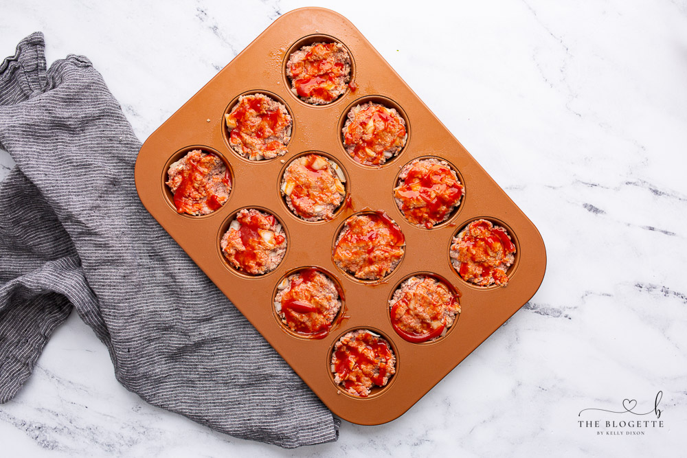 Meatloaf Muffins in a muffin tin with ketchup 