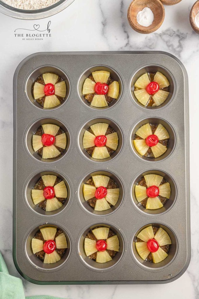 pineapples and cherries in a cupcake pan