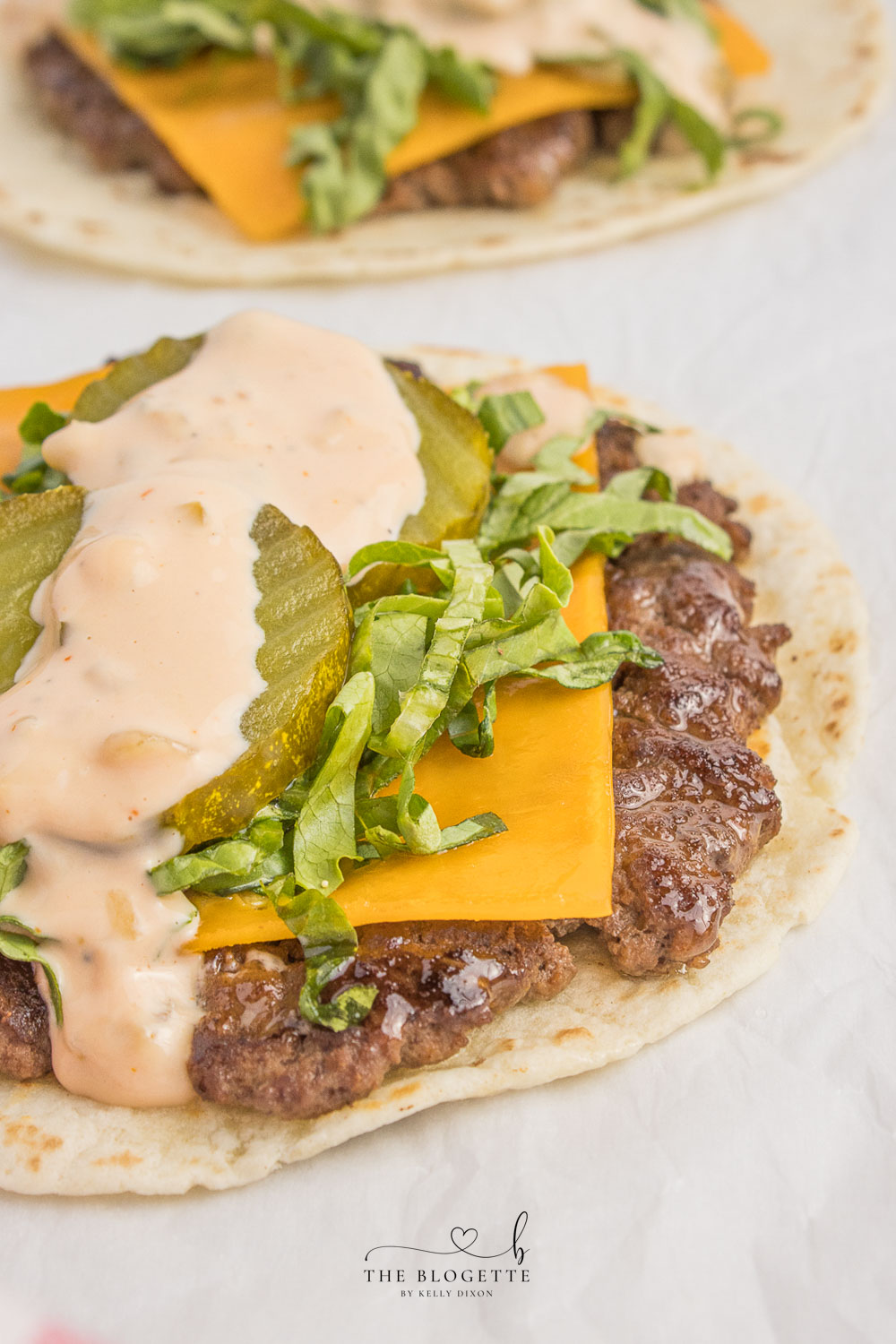 Big Mac Tacos! Juicy beef patty, melted cheddar, topped with an easy-to-make homemade Big Mac sauce! Add Taco Burgers to your menu tonight!