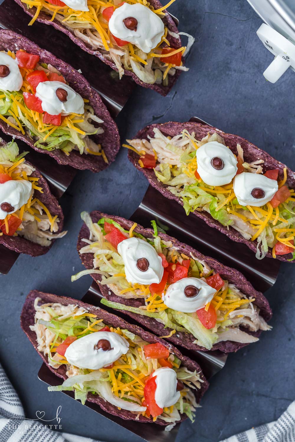 Monster Tacos for Halloween! These crock pot ranch chicken tacos feature blue corn taco shells and spooky sour cream eyes!