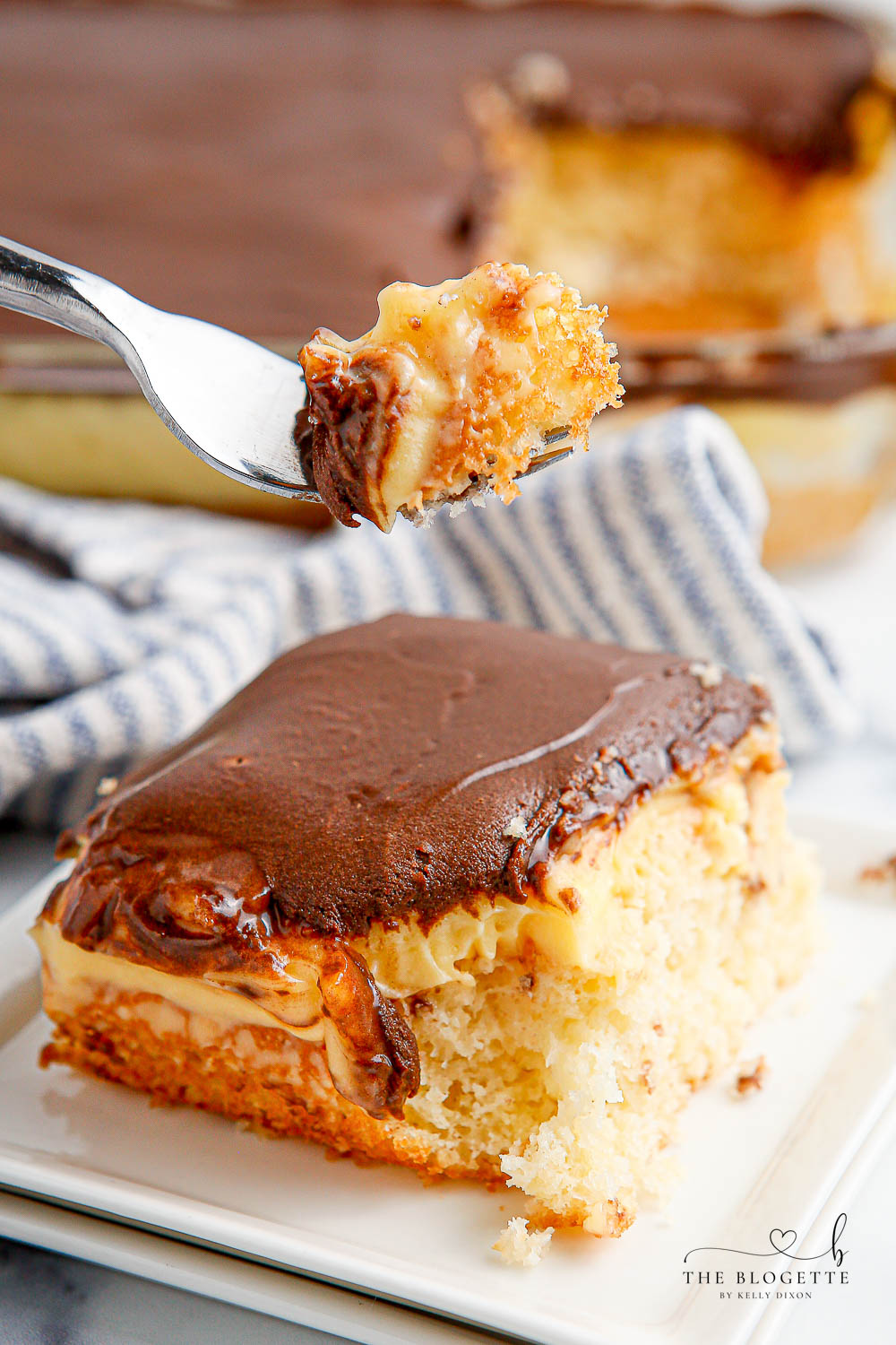 Boston Cream Poke Cake is so simple to whip up. With cake, pudding, and chocolate frosting, this cake is a quick spin on Boston Cream Pie!
