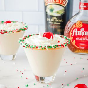 A sugar cookie cocktail for Christmas! Vanilla-rimmed martini glass filled with whipped cream vodka, Irish Cream, and Amaretto.