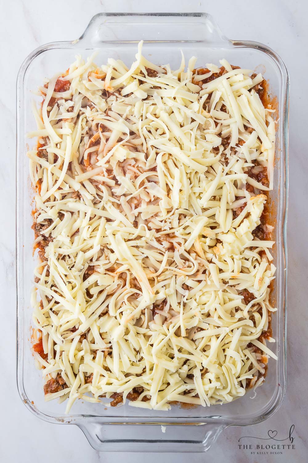 Shredded mozzarella cheese on top of lasagna