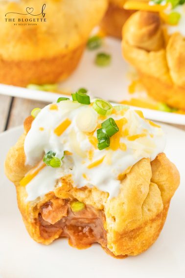 Chili stuffed rolls! Buttery biscuits surrounding chili and cheese, topped with sour cream and green onions.