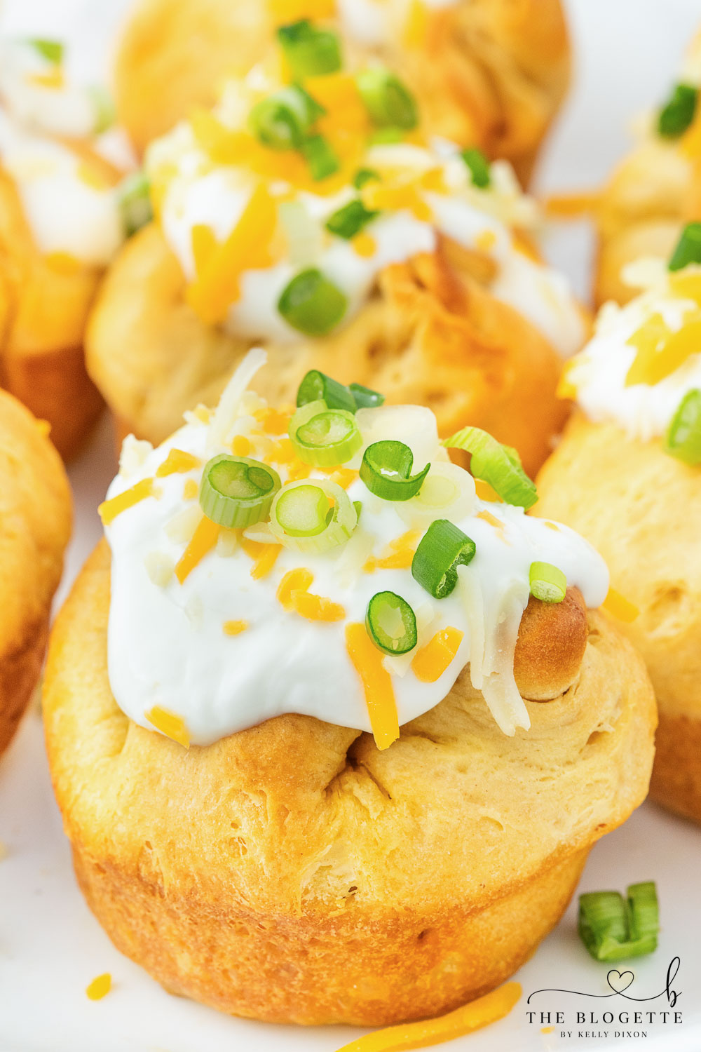 Chili stuffed rolls! Buttery biscuits surrounding chili and cheese, topped with sour cream and green onions.