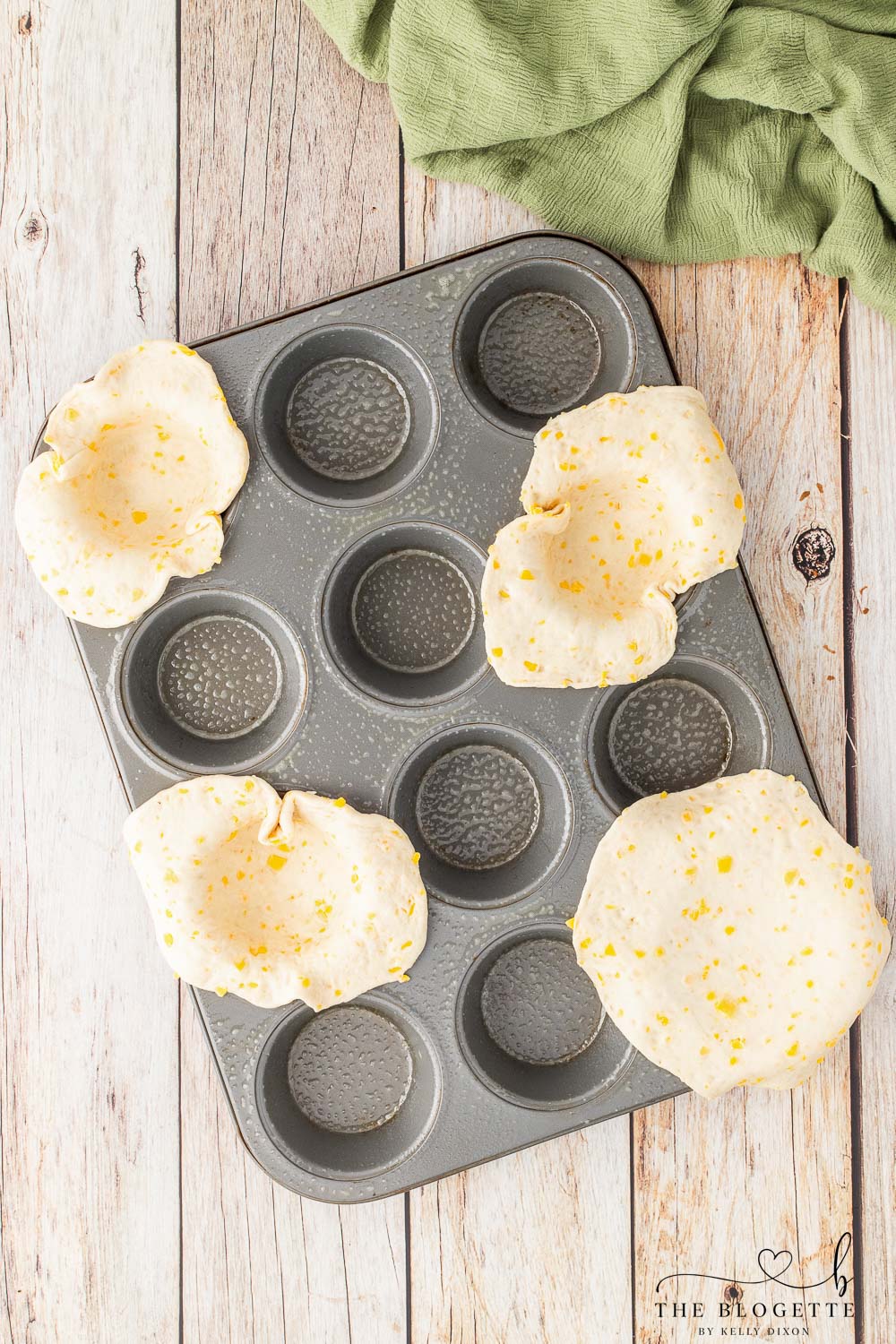 Placed rolled out biscuits into muffin tin