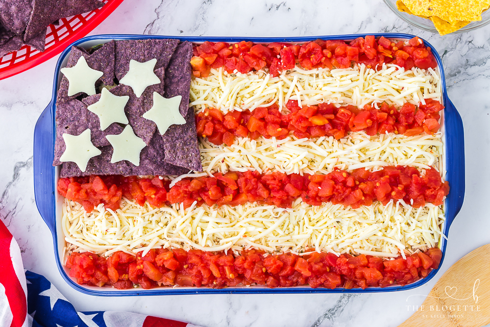 American Flag 7-Layer Dip! One of everyone's favorite 4th of July appetizers! A taco dip filled with beans, guacamole, salsa, and sour cream.