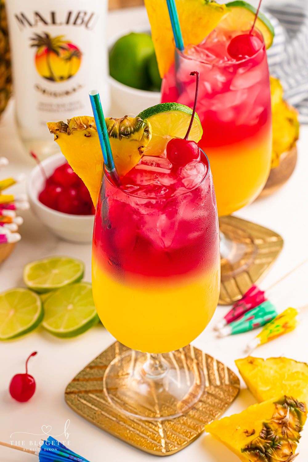 Make a beautiful Malibu Bay Breeze cocktail by layering pineapple juice, Malibu rum, and cranberry juice! Perfect all spring and summer long!