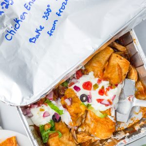These Freezer Chicken Enchiladas make busy-night dinners so much easier! Crockpot chicken, black beans, green chiles, red enchilada sauce, and plenty of melted cheese come together in a recipe that makes TWO pans. Bake one tonight and freeze one for later!